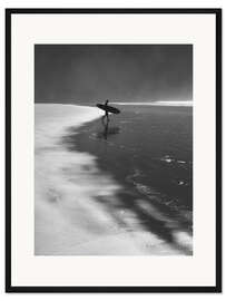 Gerahmter Kunstdruck A lone surfer on his way into the sea.