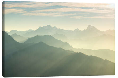 Canvas print Sunlight behind mountain peaks silhouette, the Alps