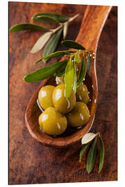 Aluminium print Spoon with green olives on a wooden table