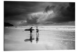 Aluminiumtavla Surfers on a stormy tropical beach