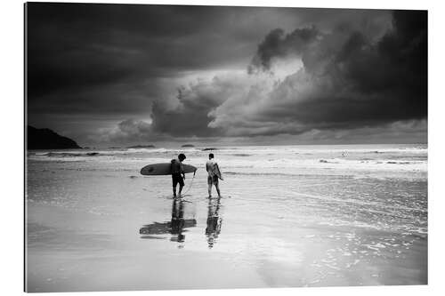 Tableau en plexi-alu Surfeurs sur une plage tropicale orageuse