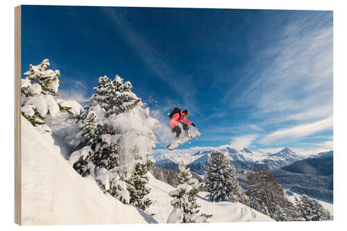 Obraz na drewnie Snowboarder jumps over trees