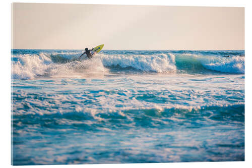 Acrylic print Surfing in the ocean at sunset