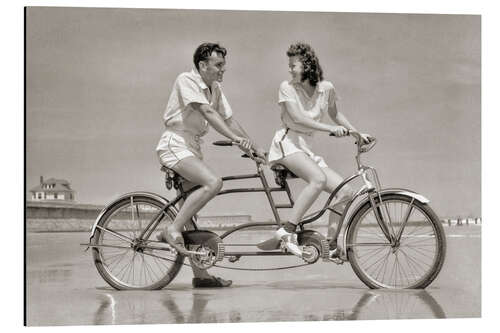 Stampa su alluminio Young couple riding a tandem bike on the beach, 1940s