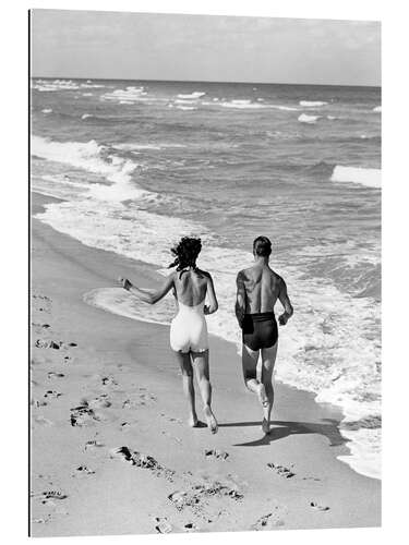 Tableau en plexi-alu Couple wearing jogging at edge of ocean beach, 1930's