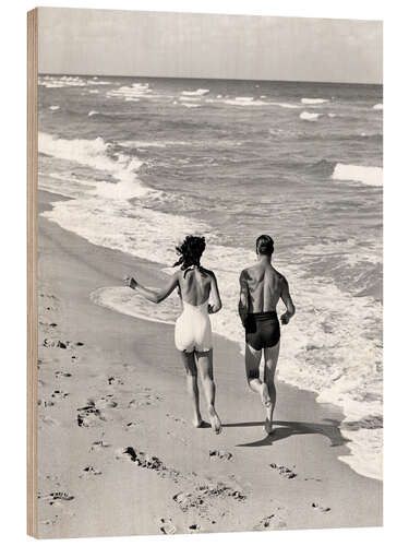 Trebilde Couple wearing jogging at edge of ocean beach, 1930's