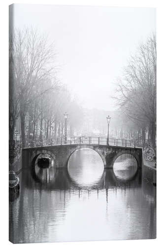 Lienzo Misty morning over a historic Amsterdam canal bridge