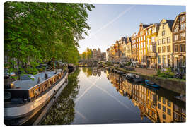 Canvas print Sunlight on a calm canal in Amsterdam, Netherlands - George Pachantouris